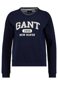 Felpa blu navy con il testo stampato bianco "GANT 1949 NEW HAVEN." Presenta polsini e orlo a costine, una consistenza morbida e un design con collo a giro.