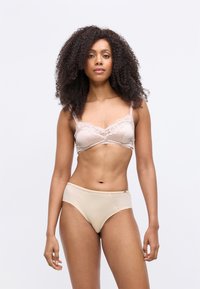 Beige Spitzen-BH mit verstellbaren Trägern und passender hoch taillierter Unterhose, die eine glatte Textur und subtile gestreifte Akzente aufweist.