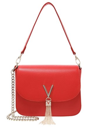 Sac bandoulière en cuir rouge avec fermeture à rabat, bandoulière en chaîne et quincaillerie en argent, présentant un grelot et un accent logo. Surface texturée.