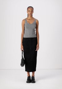 Hallide ribadega hall särk, mis on kombineeritud musta nööpidega midi-seeliku ja mustade libisemisjalanõudega. Outfit'i täiendab väike käekott.