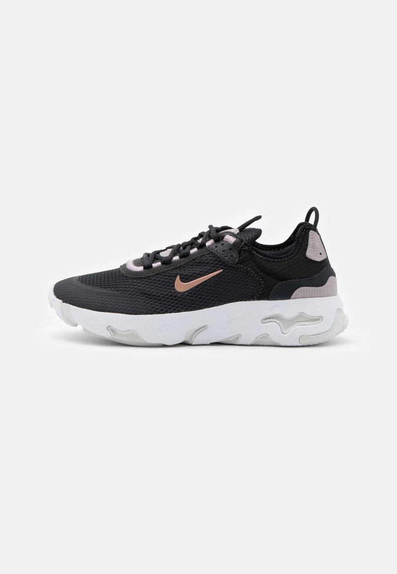 Čierne a šedé tenisky s priedušným zvrškom, bielou gumovou podrážkou a svetloružovými akcentmi. Výrazné logo Nike na boku.