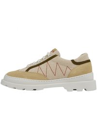 Beige and tan sneaker with a textured canvas upper, contrasting olive green accents, red zigzag stitching, and a thick white rubber sole.
