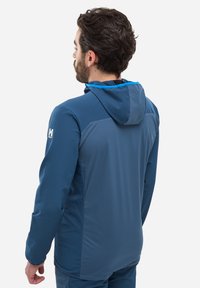 Veste à capuche bleue avec une texture lisse, ornée d'une bordure contrastante bleu clair et d'un logo sur l'épaule gauche.