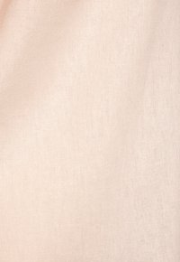 Beige fabric with a smooth, slightly textured surface. The material appears lightweight and soft, suitable for draping or garment use.