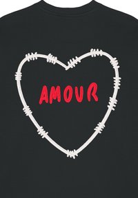 Felpa nera con un contorno di cuore ricamato in bianco decorato con accenti di filo spinato. La parola "AMOUR" è ricamata in rosso all'interno del cuore.