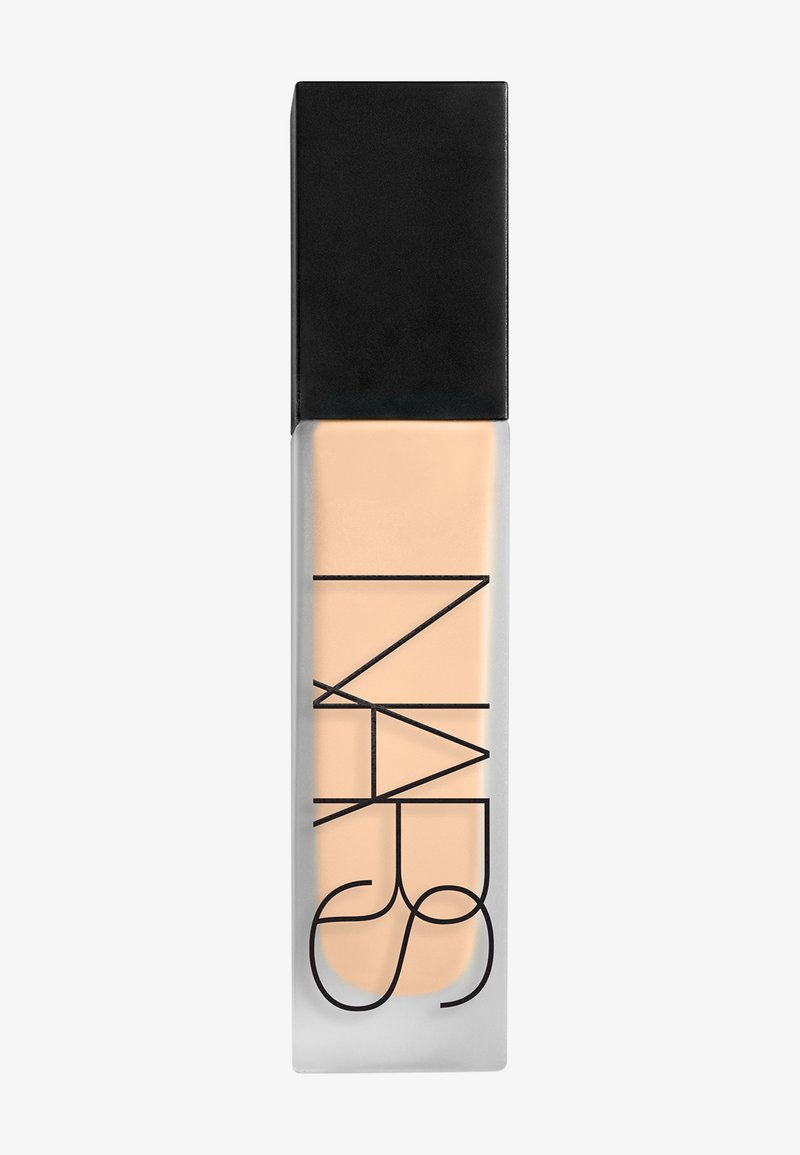 Bouteille rectangulaire en verre contenant un fond de teint liquide beige, avec un bouchon noir et le logo NARS noir sur le devant.