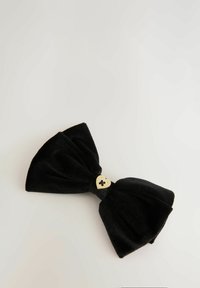 Fascia per capelli in velluto nero con finitura testurizzata, dettagli centrali in hardware a forma di cuore dorato. Presenta due anelli e un centro annodato.