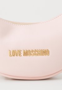 Halvány rózsaszín műbőr táska ívelt formával; aranyszínű cipzárral és arany színű, dombornyomott "LOVE MOSCHINO" logóval rendelkezik.
