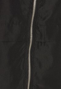 Black jacket featuring a silver zipper, smooth fabric texture, and a simple design with minimal detailing.