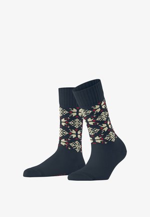 Chaussettes navy avec un bord côtelé présentant un motif géométrique de flocon de neige crème et rouge. Texture douce avec un renfort au niveau des orteils et du talon pour plus de durabilité.