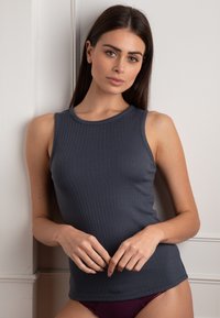 Top senza maniche a coste di colore blu navy, realizzato in tessuto morbido. Presenta un collo rotondo e una silhouette aderente, con dettagli di design minimalisti.