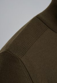 Olive-zielony sweter z dzianiny z prążkowaną strukturą na ramionach i dekolcie, z gładkim wykończeniem na korpusie.