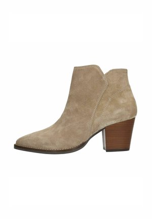 Beige suède enkellaars met een spitse neus, een schuine snit aan de zijkanten en een gestapelde houten hak. Bevat subtiele stikdetails.
