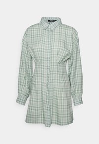 Camisa botão de xadrez verde e branca, com mangas longas, gola, tecido macio, design ligeiramente ajustado, com um padrão de xadrez consistente por todo o lado.