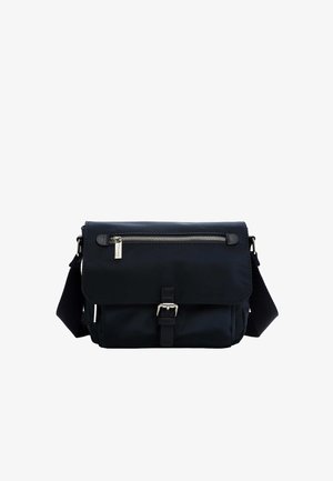 Tumši zils neilona messenger soma ar vāku, sudraba rāvējslēdzēja kabatu un regulējamu siksnu. Priekšpusē ir sprādzes detaļa.