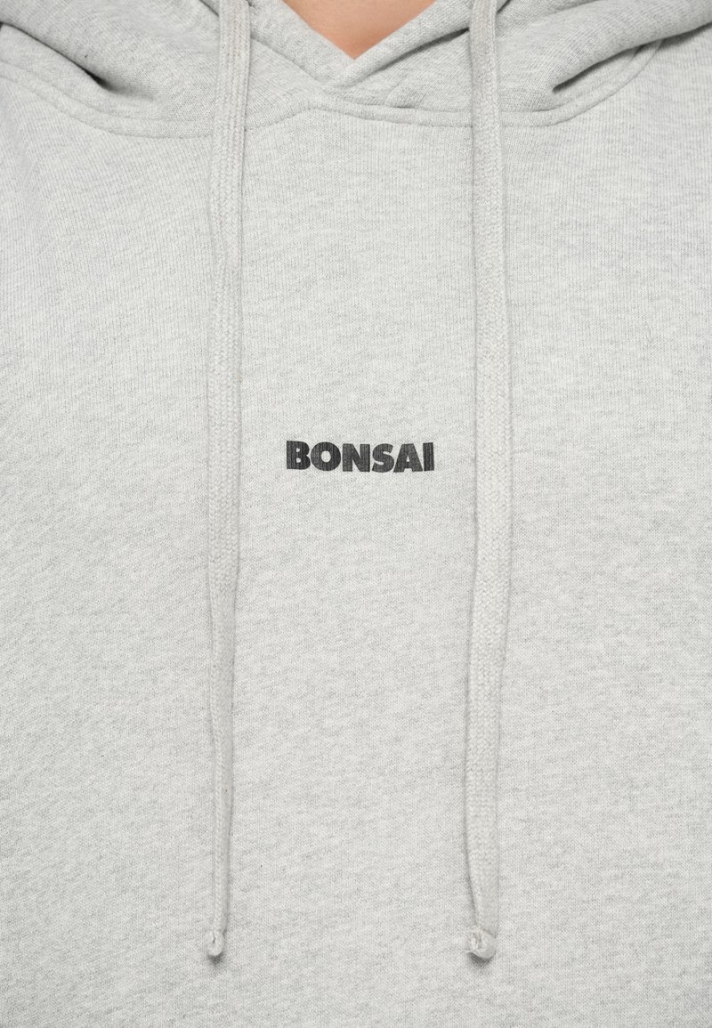 Light gray sweatshirt with a hood, featuring a front kangaroo pocket, drawstrings, and the word "BONSAI" in bold black lettering.