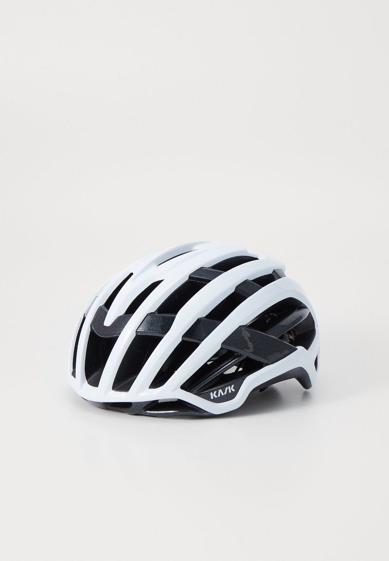 Casque de cyclisme blanc et noir avec un design aérodynamique, comportant plusieurs aérations et une coque légère et élégante pour la ventilation.