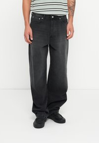 Black, wide-leg jeans in denim fabric with a faded finish; features a classic five-pocket design and metal hardware for closure.