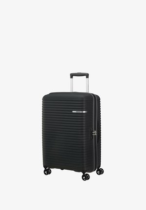 Black hard-shell suitcase with horizontal ridges, silver zipper, and built-in lock. Features a retractable handle and four swivel wheels.