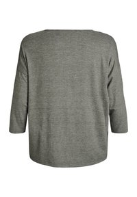 Grå, texturerad topp med lång ärm och en lös, boxig passform. Har en rund hals och sänkta axlar, vilket visar ett mjukt tyg.