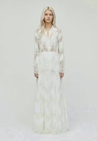 Lace long-sleeve dress in white with a collared neckline, featuring floral embroidery and a flowing skirt that extends to the floor.