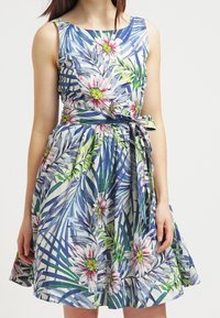 Robe à imprimé floral avec un corsage ajusté, une jupe évasée et une taille ceinturée. Les matériaux incluent un tissu avec des motifs bleus, verts et roses.