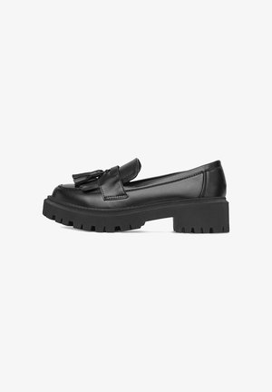 Černé kožené mokasíny s mohutnou podrážkou, nízkým blokovým podpatkem a dekorativními třásněmi na vrchu, boční pohled na bílém pozadí.