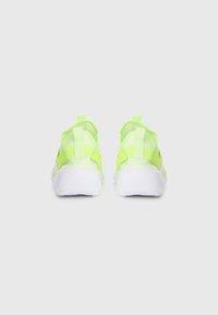 Baskets de sport en néon jaune avec des matériaux en maille et synthétiques, semelles blanches et double tirant pour un enfilage facile. Design minimaliste.