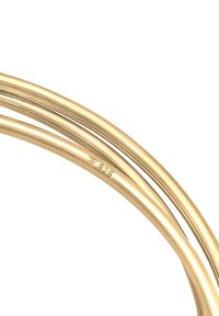 Armband i sterlingsilver med en polerad gyllene finish, som har släta, rundade mönster och ett stämplat äkthetsmärke "925."