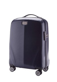 Valise rigide de couleur bleu marine avec une surface texturée, comprenant une poignée supérieure, quatre roues et une plaque logo en métal.