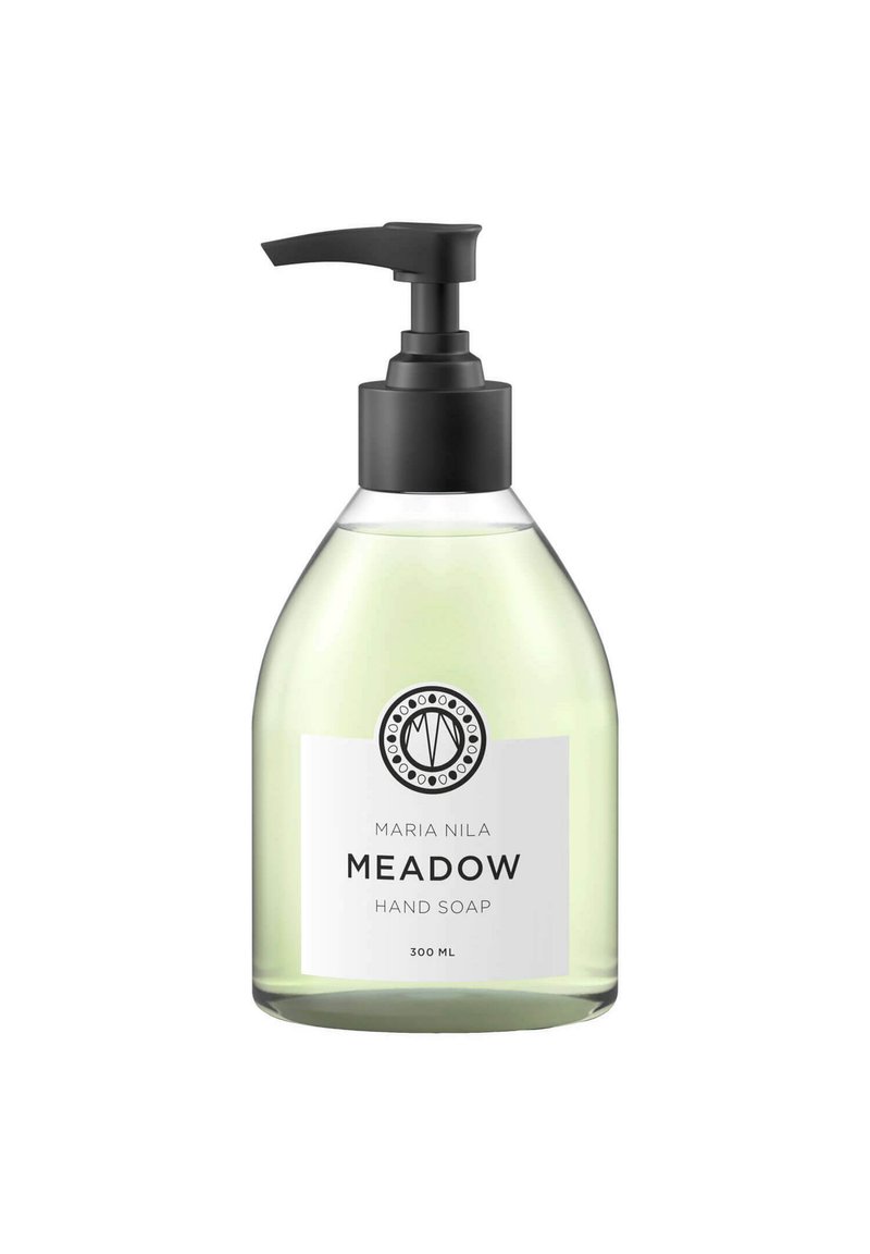 Pompfles van handzeep; helder glas met een groene vloeistof, zwarte pomp en een wit etiket met de tekst "Maria Nila Meadow" en logo.