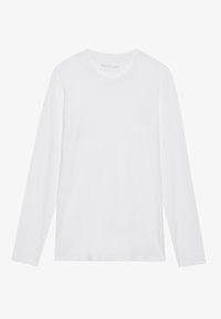 T-shirt à col rond à manches longues, blanc uni, posé à plat avec le nom de la marque visible à l'intérieur du col sur un fond blanc.
