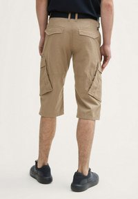 Beige cargo shorts, knælange, med to sidelommer og et struktureret stof. Bagfra ses to baglommer med klap og en talje.