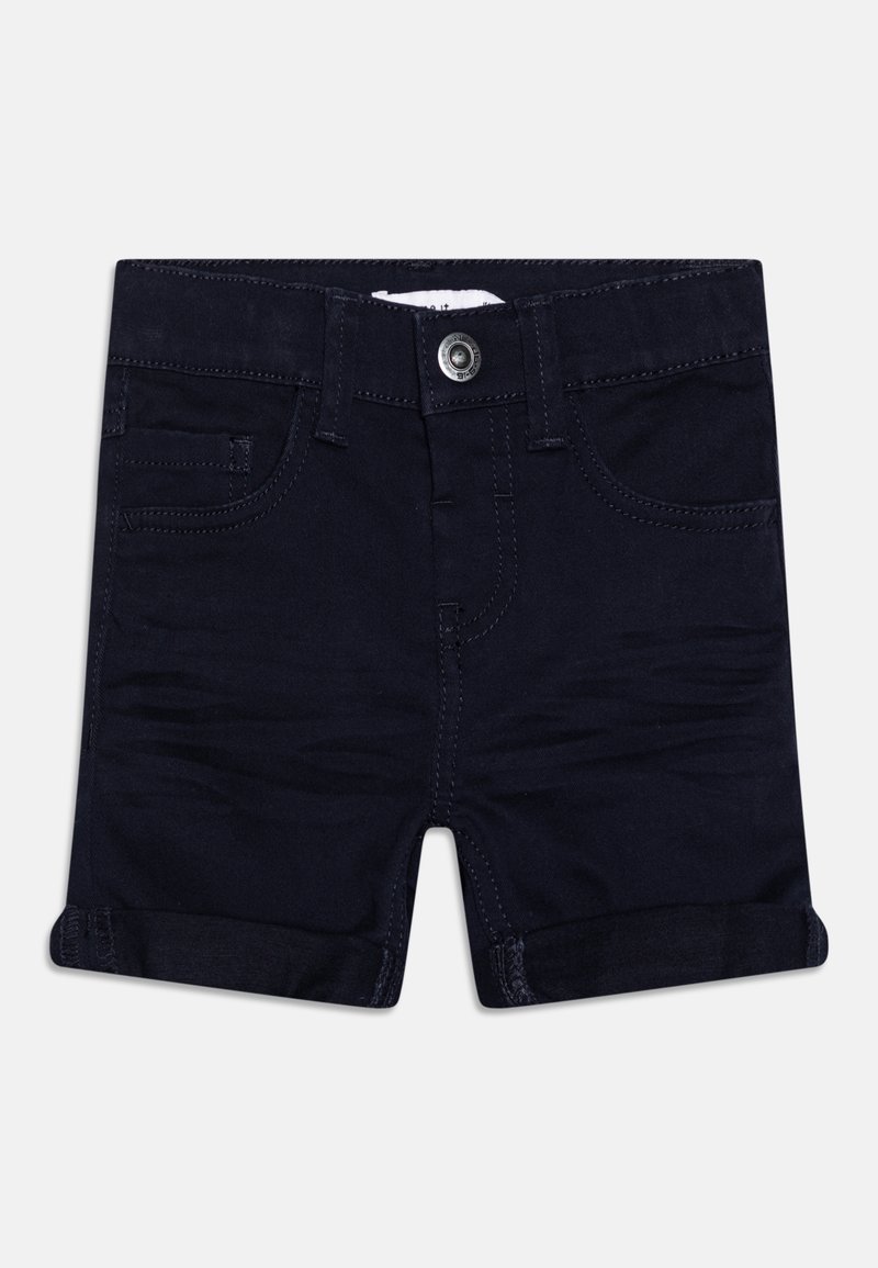 Short en denim bleu foncé avec ourlets roulés, bouton à l’avant, passants de ceinture et poches avant et poche monnaie, posé à plat sur un fond blanc.