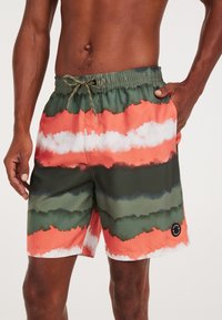 Zwemshorts met een meerkleurig, abstract patroon in tinten van groen, oranje en wit. Heeft een elastische tailleband en zijzakken.