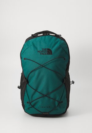 Mochila en color teal y negro fabricada con un material duradero, que cuenta con un sistema de cuerda elástica en la parte frontal y el logo "The North Face" destacado.