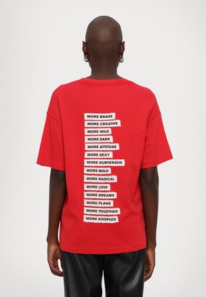 Camiseta de algodón roja con una lista de frases motivacionales impresas en blanco en la parte trasera, dispuestas en alineación vertical. Mangas cortas.
