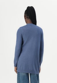 Stickad långärmad tröja i mjukt blått ull, med rund halsringning och ribbade muddar, fåll med rak snitt och lätt textur.