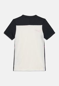 Camiseta deportiva en blanco y negro de manga corta; cuenta con una espalda de malla texturizada y acentos laterales rojos; incluye un pequeño logo en la parte superior de la espalda.