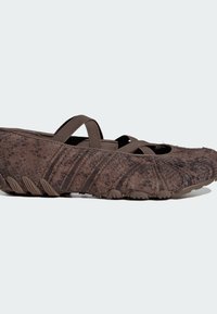 Brown textured ballet flat with crisscross elastic straps and rubber sole with grip tread detail.