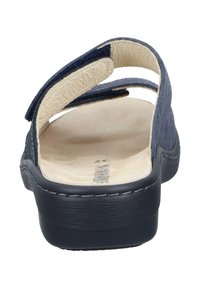 Sininen mokkasandaali, jossa on kaksi säädettävää nauhaa, beige pehmeä sisäpohja ja paksu musta pohja. Saumauksia reunassa.