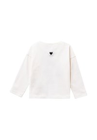 Camicia bianca a maniche lunghe con una toppa nera a forma di cuore e il testo "IKKS" centrato sulla parte superiore della schiena.