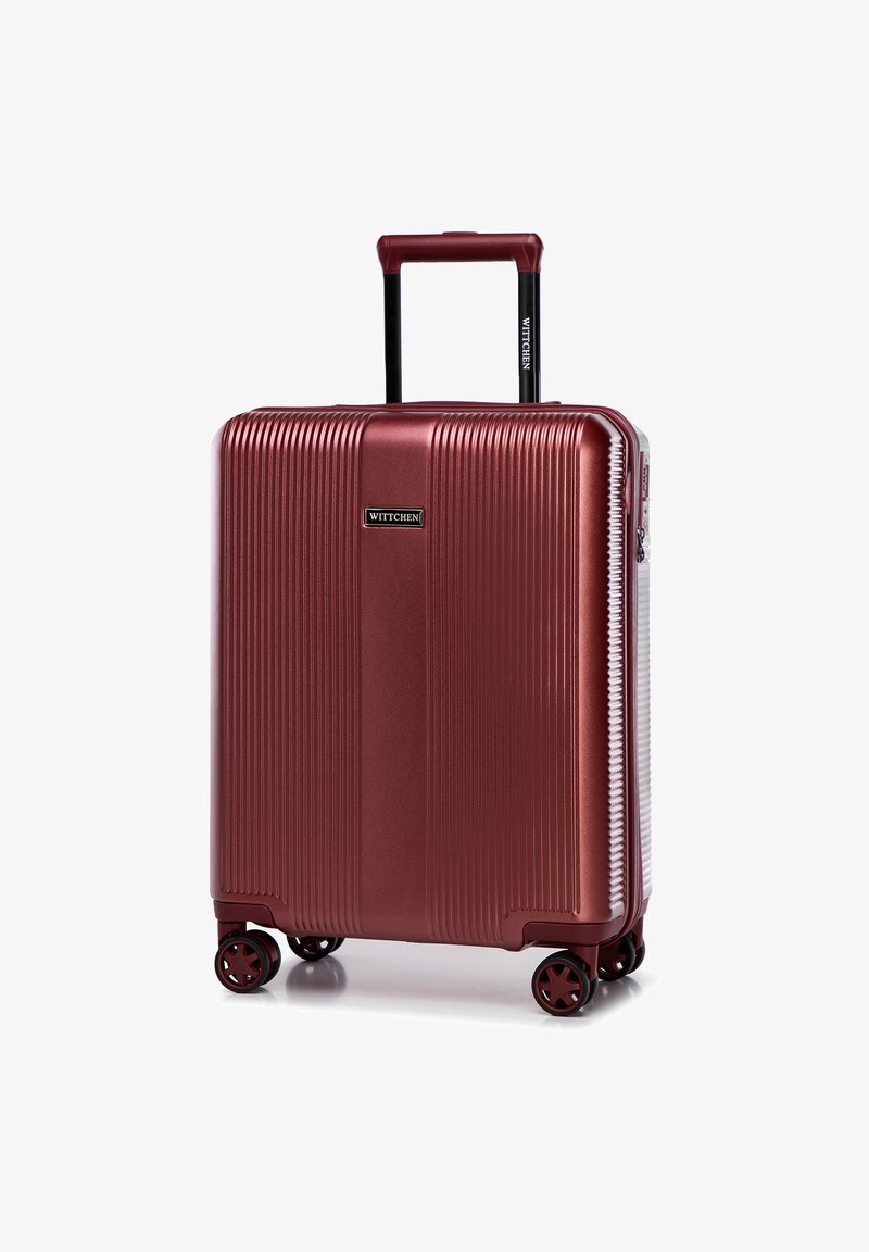 Tvrdý červený kufr s čtyřmi dvojitými otáčivými kolečky a prodlouženou teleskopickou rukojetí, značka Wittchen viditelná vpředu a na rukojeti.