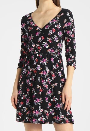 Sort blomsterkjole med lange ærmer, V-udskæring og en indsnævret talje. Har farverige blomster i nuancer af pink, orange og hvid.