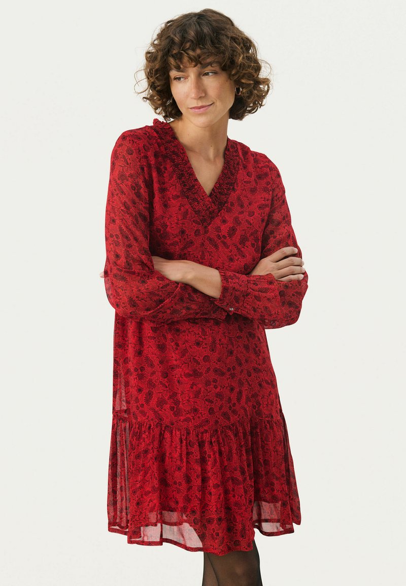 Rotes Blumenkleid mit V-Ausschnitt, langen Ärmeln und rüschengesäumtem Saum. Hergestellt aus leichtem Stoff, mit einem zarten Blumenmuster.