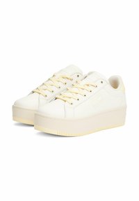 Baskets plateforme en simili cuir blanc avec un bout rond, des accents jaunes et une semelle en caoutchouc texturé. Elles disposent de lacets et de détails sur les panneaux latéraux.