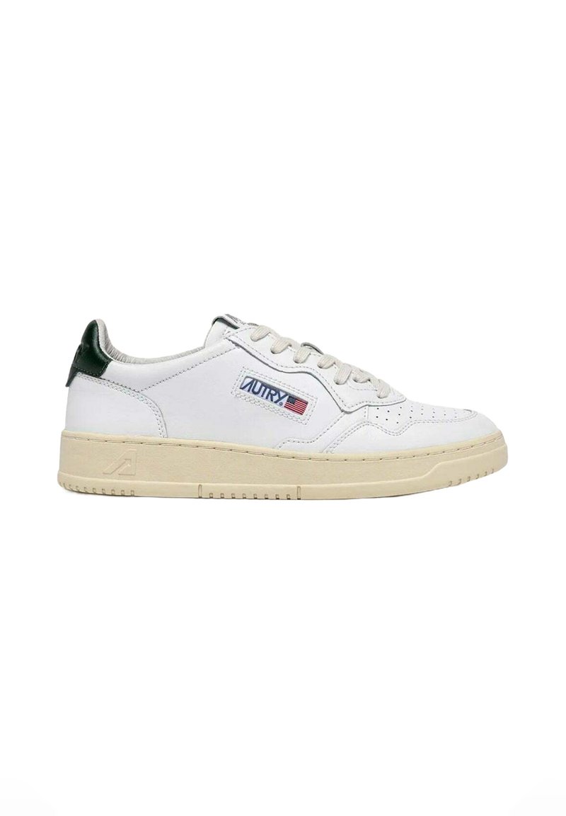 Hvide lædersneakers med perforeret tå, grøn detalje på hælen, snørebånd og mærke med røde, hvide og blå elementer. Gummisål.