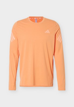 Long-sleeve, peach-colored athletic shirt with crew neck, light pink Adidas logo on chest, and three stripes on each sleeve.