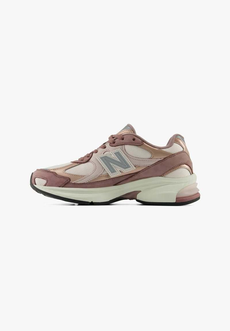 Πλάγια όψη ροζ και μπεζ παπουτσιού New Balance με πάνελ από δίχτυ και δέρμα και παχύ άσπρο πέλμα.
