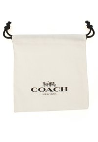 Weißer Leinensack mit schwarzem Zugband, bedruckt mit "COACH NEW YORK" und einer Coach-Grafik in Schwarz. Glatte Textur, schlichtes Design.